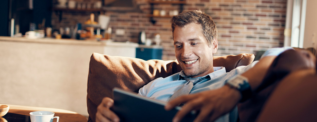 Man using Tablet while sitting on couch