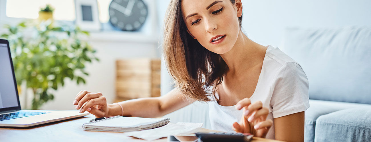 Woman using calculator at desk